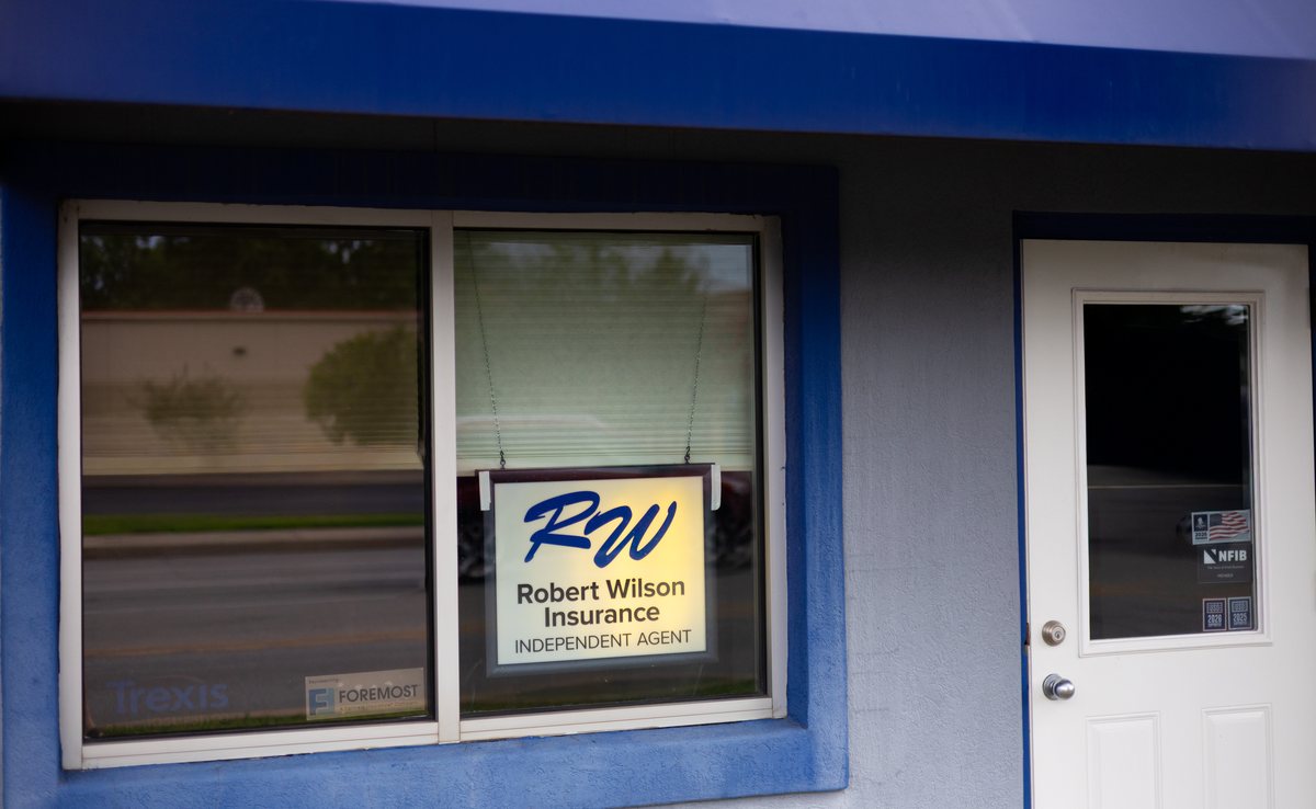 Robert Wilson Insurance independent agent sign lit in the office window in Terre Haute